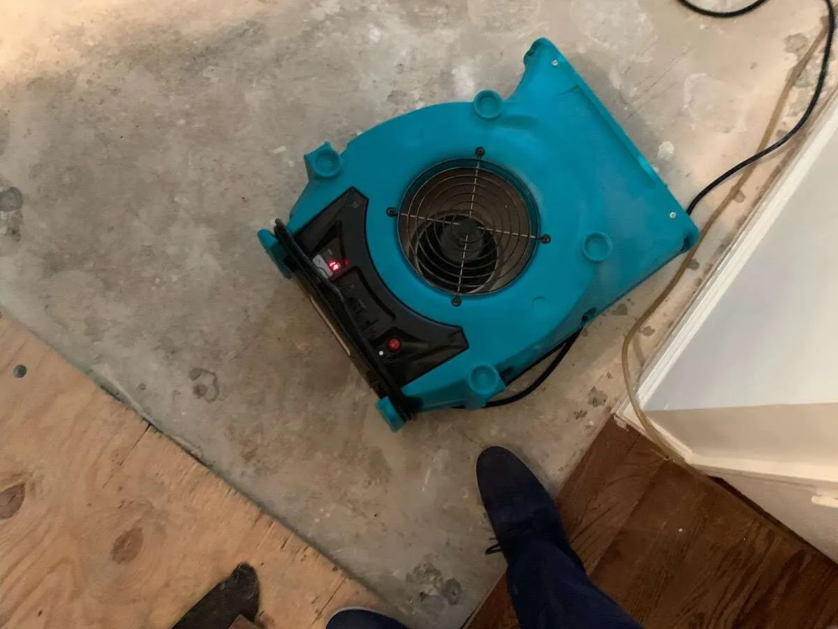 Air mover drying subfloor during Commercial Water Damage Restoration in Wellsville